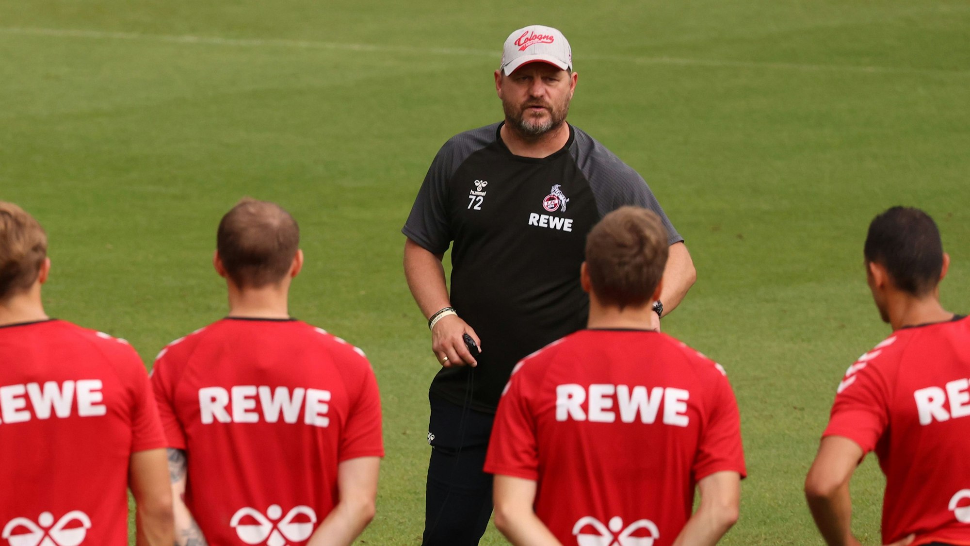 Steffen Baumgart spricht im FC-Training mit seinen Schützlingen.