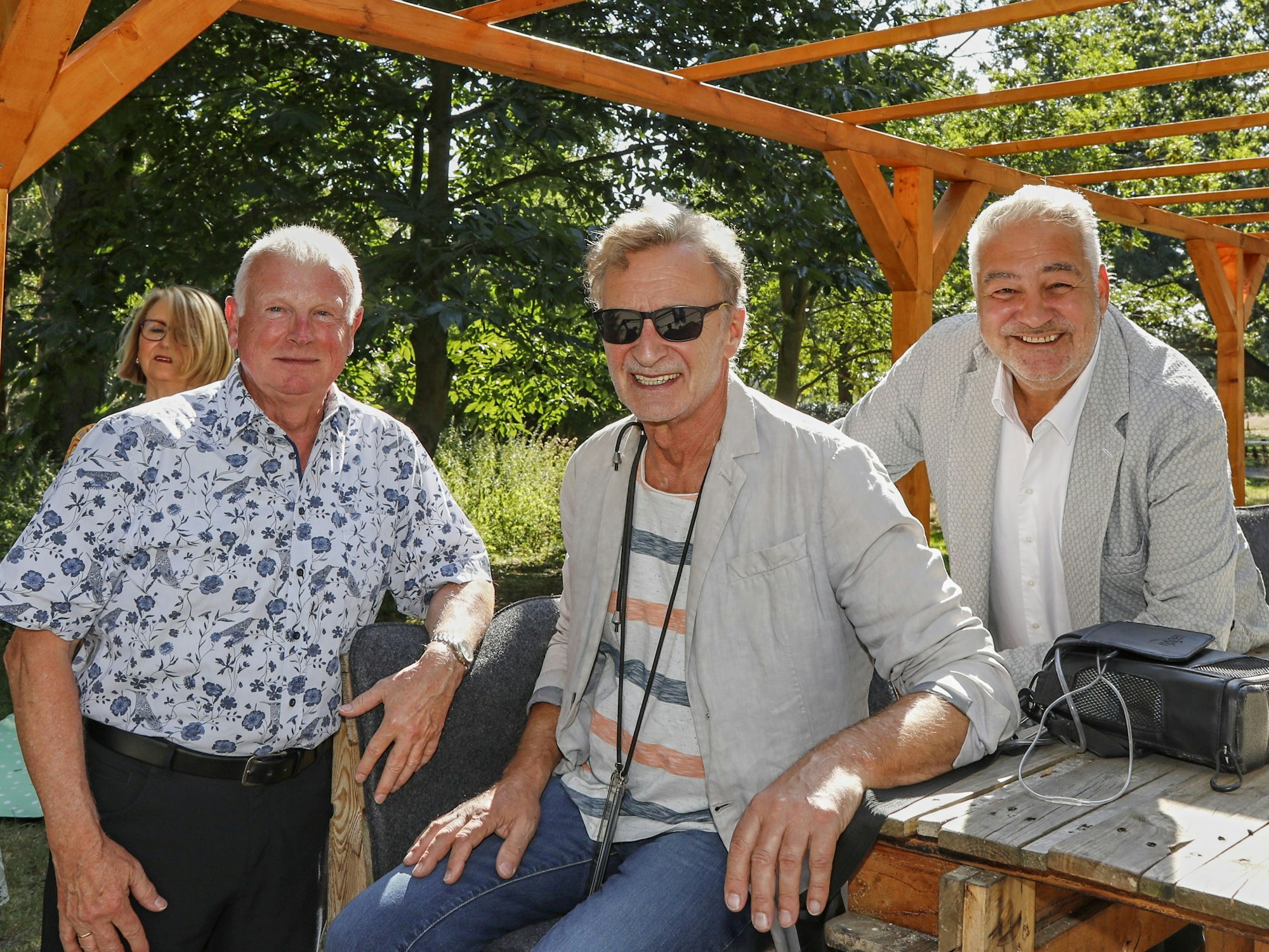 Karnevalist Werner Beyer, Musikproduzent Reiner Hömig und Dirk Metzner, Chef vom Kölner Lindner Hotel, lächeln in die Kamera.