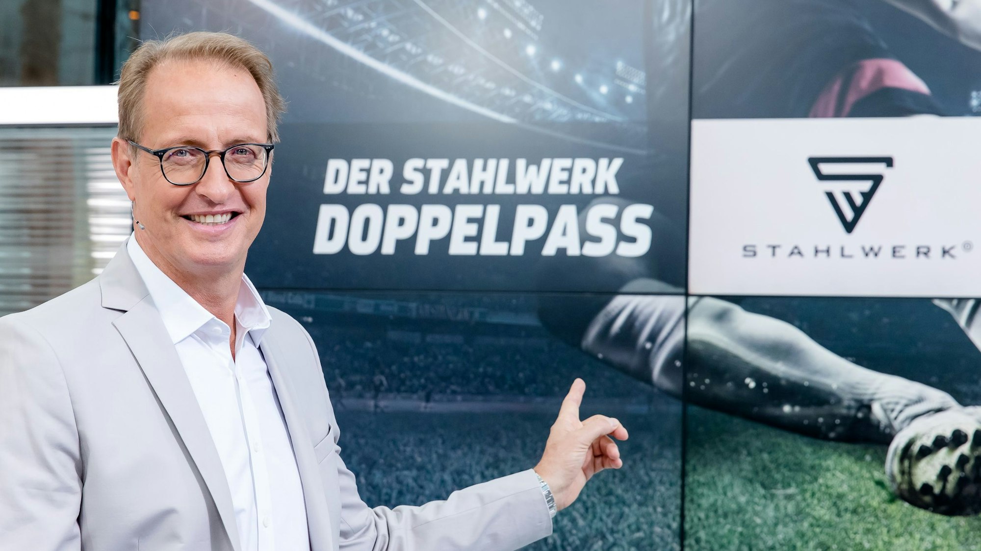 Florian König zeigt auf das Logo vom Sport1-Doppelpass