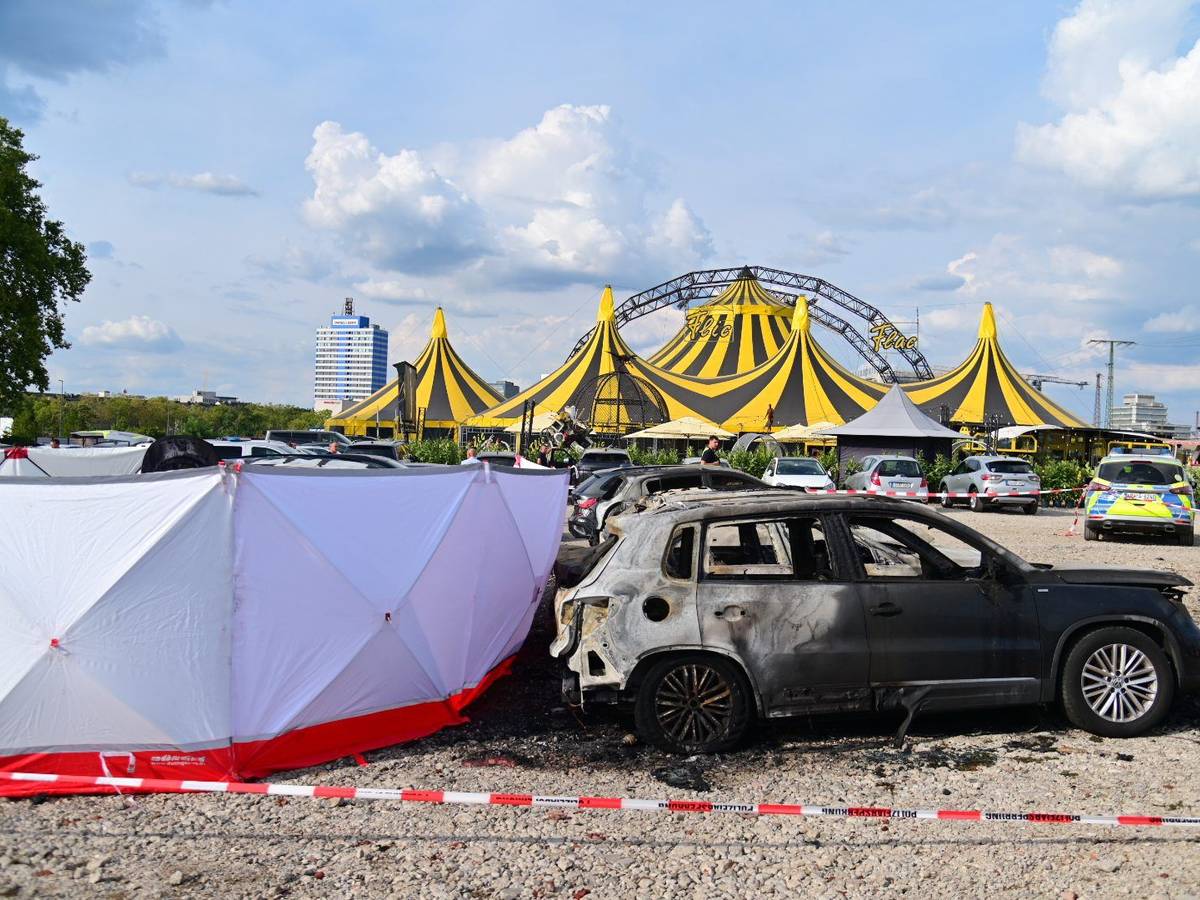 04.09.2022, Nordrhein-Westfalen, Duisburg: Ausgebrannte Fahrzeuge stehen vor dem Zelt des Zirkus FlicFlac, nachdem dort ein Kleinflugzeug abgestürzt war; die Unglücksstelle ist mit Sichtschutz umstellt. Beim dem Absturz des kleinmotorigen Flugzeugs in der Nähe der Autobahn A59 bei Duisburg sind zwei Menschen ums Leben gekommen. Foto: Christoph Reichwein/dpa +++ dpa-Bildfunk +++