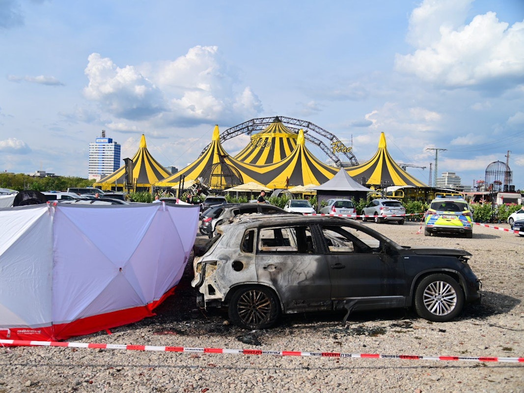 04.09.2022, Nordrhein-Westfalen, Duisburg: Ausgebrannte Fahrzeuge stehen vor dem Zelt des Zirkus FlicFlac, nachdem dort ein Kleinflugzeug abgestürzt war; die Unglücksstelle ist mit Sichtschutz umstellt. Beim dem Absturz des kleinmotorigen Flugzeugs in der Nähe der Autobahn A59 bei Duisburg sind zwei Menschen ums Leben gekommen. Foto: Christoph Reichwein/dpa +++ dpa-Bildfunk +++