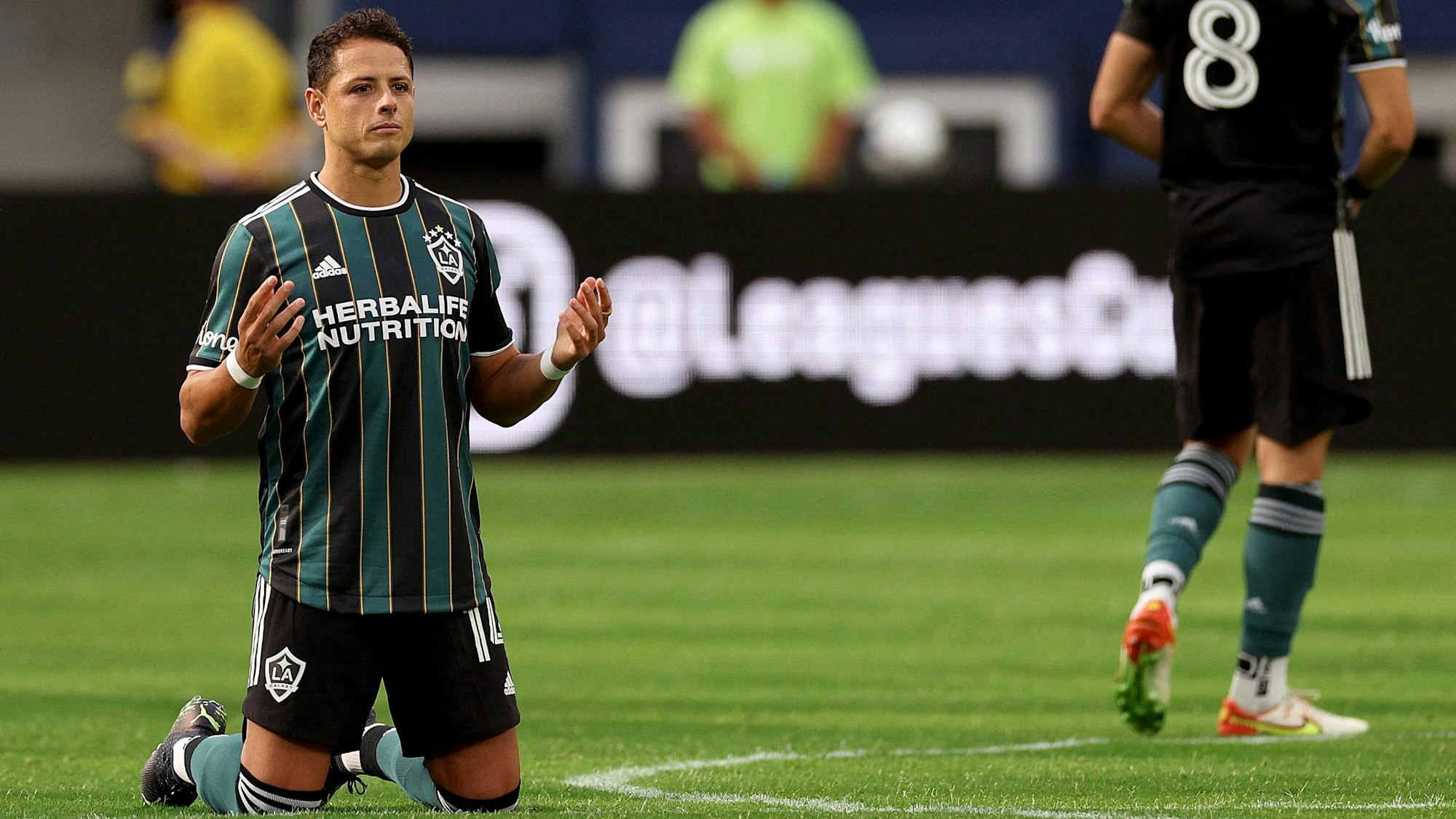 Der frühere Bundesliga-Stürmer Chicharito kniet beim Spiel von LA Galaxy gegen Deportivo Guadalajara auf dem Rasen.