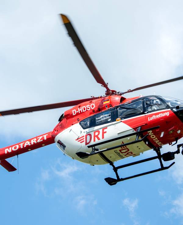 Ein Rettungshelikopter der DRF Luftrettung landet auf einer Wiese am Flughafen Hannover.