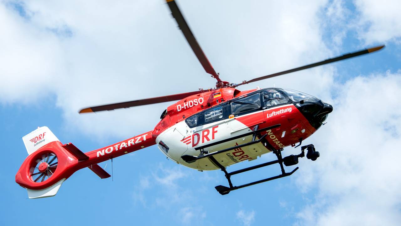 Ein Rettungshelikopter der DRF Luftrettung landet auf einer Wiese am Flughafen Hannover.