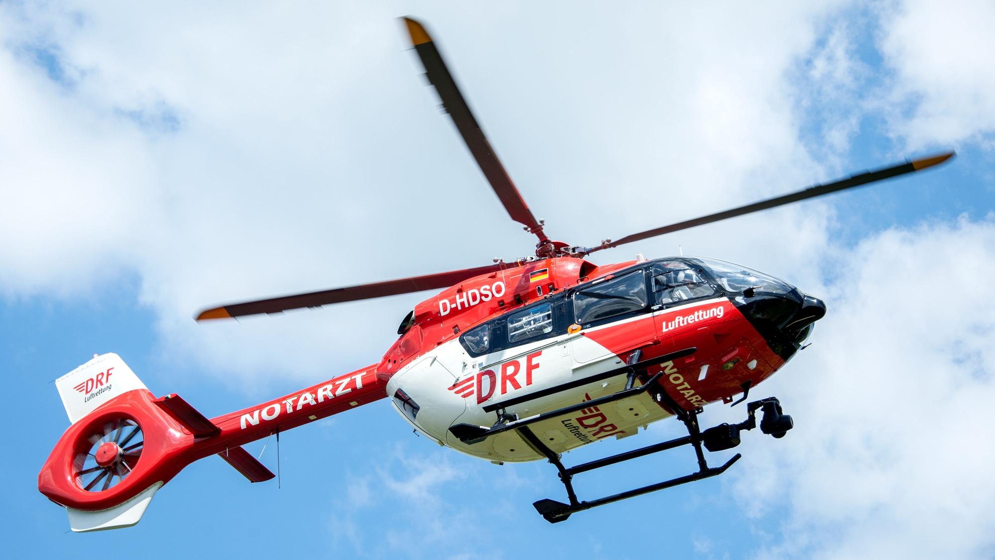 Ein Rettungshelikopter der DRF Luftrettung landet auf einer Wiese am Flughafen Hannover.