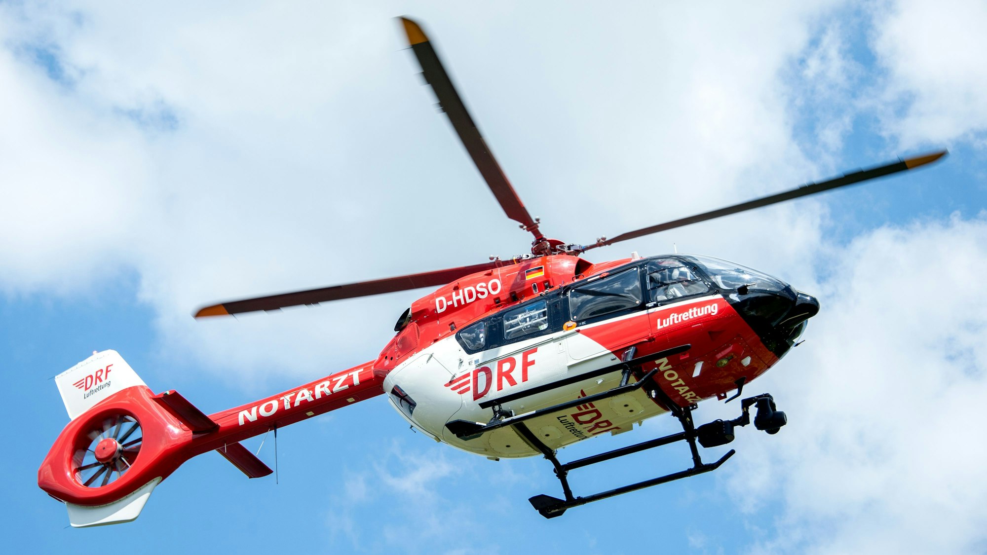 Ein Rettungshelikopter der DRF Luftrettung landet auf einer Wiese am Flughafen Hannover.