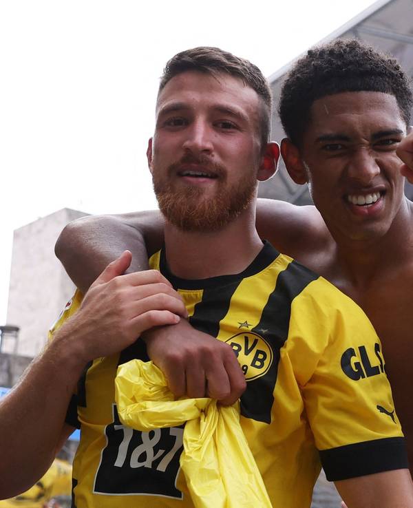 Jude Bellingham legt einen Arm um Salih Özcan und ballt mit der anderen Hand die Faust.