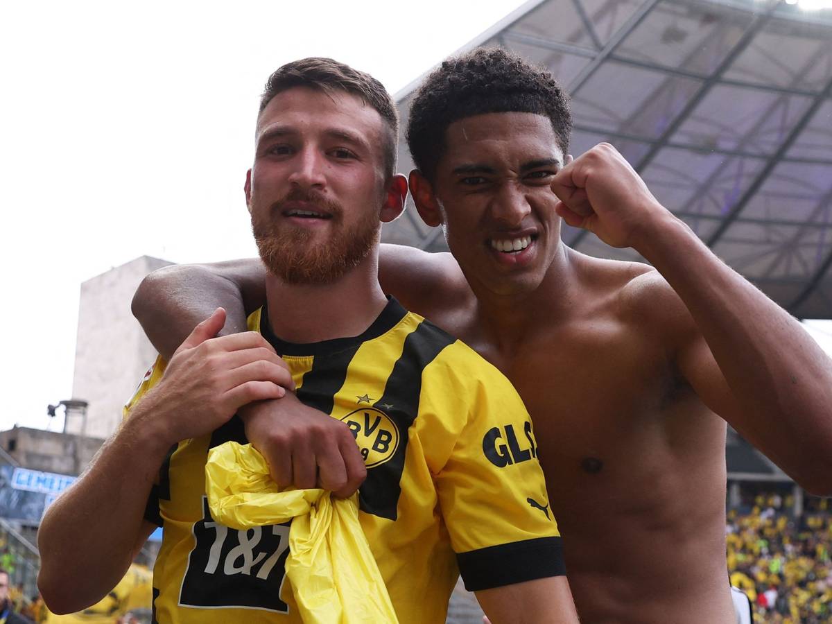 Jude Bellingham legt einen Arm um Salih Özcan und ballt mit der anderen Hand die Faust.