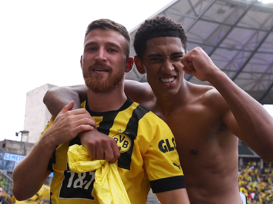 Jude Bellingham legt einen Arm um Salih Özcan und ballt mit der anderen Hand die Faust.