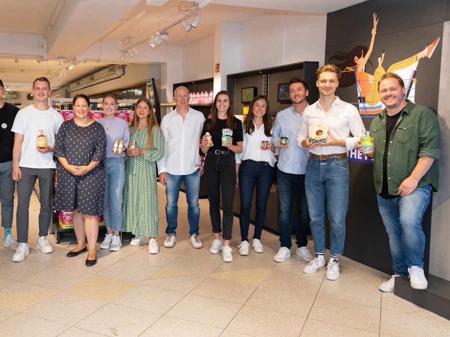 Junge Gründer aus Köln zeigen ihre Produkte in die Kamera.