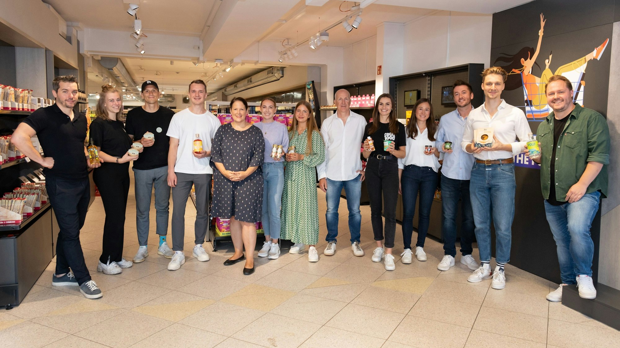 Junge Gründer aus Köln zeigen ihre Produkte in die Kamera.