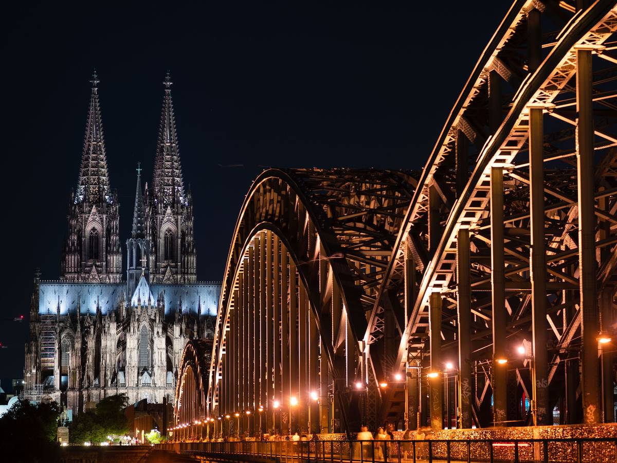 Das Foto zeigt den beleuchteten Dom und die Hohenzollern Brücke.