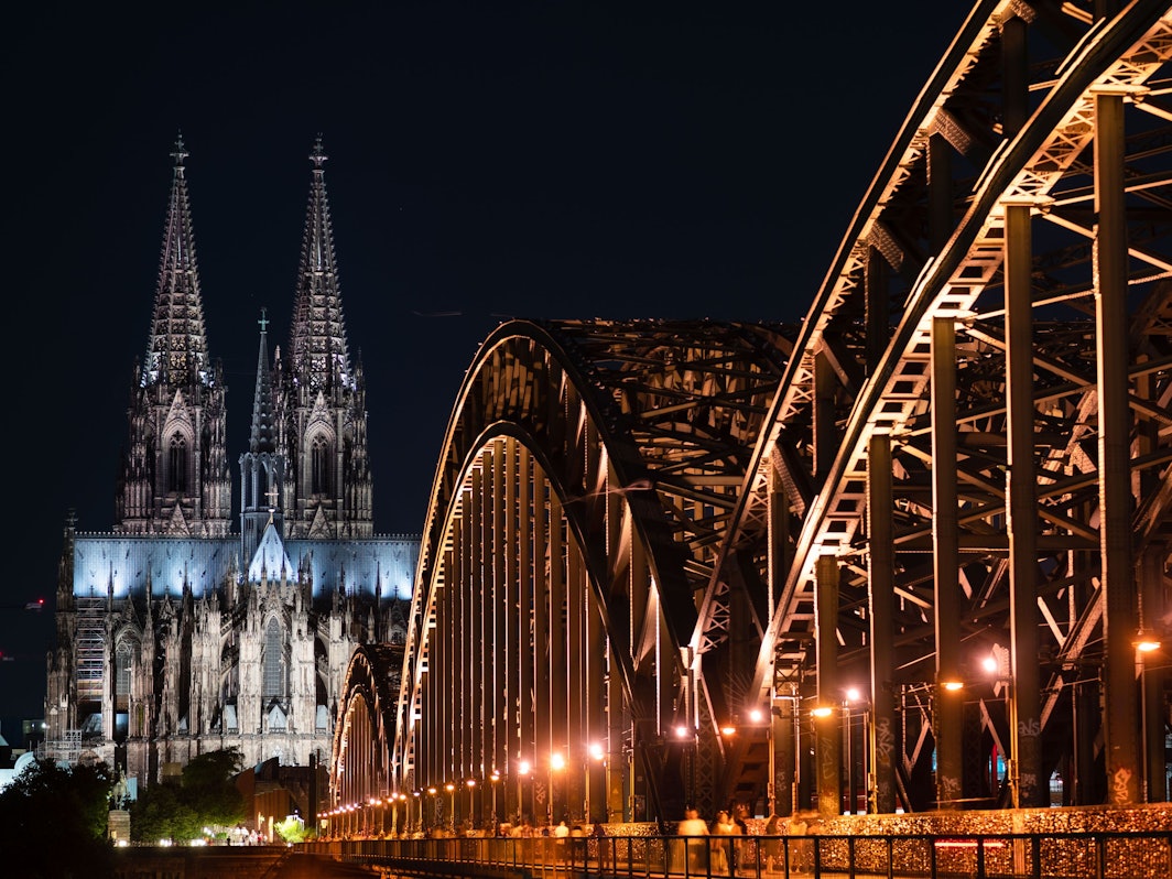 Das Foto zeigt den beleuchteten Dom und die Hohenzollern Brücke.