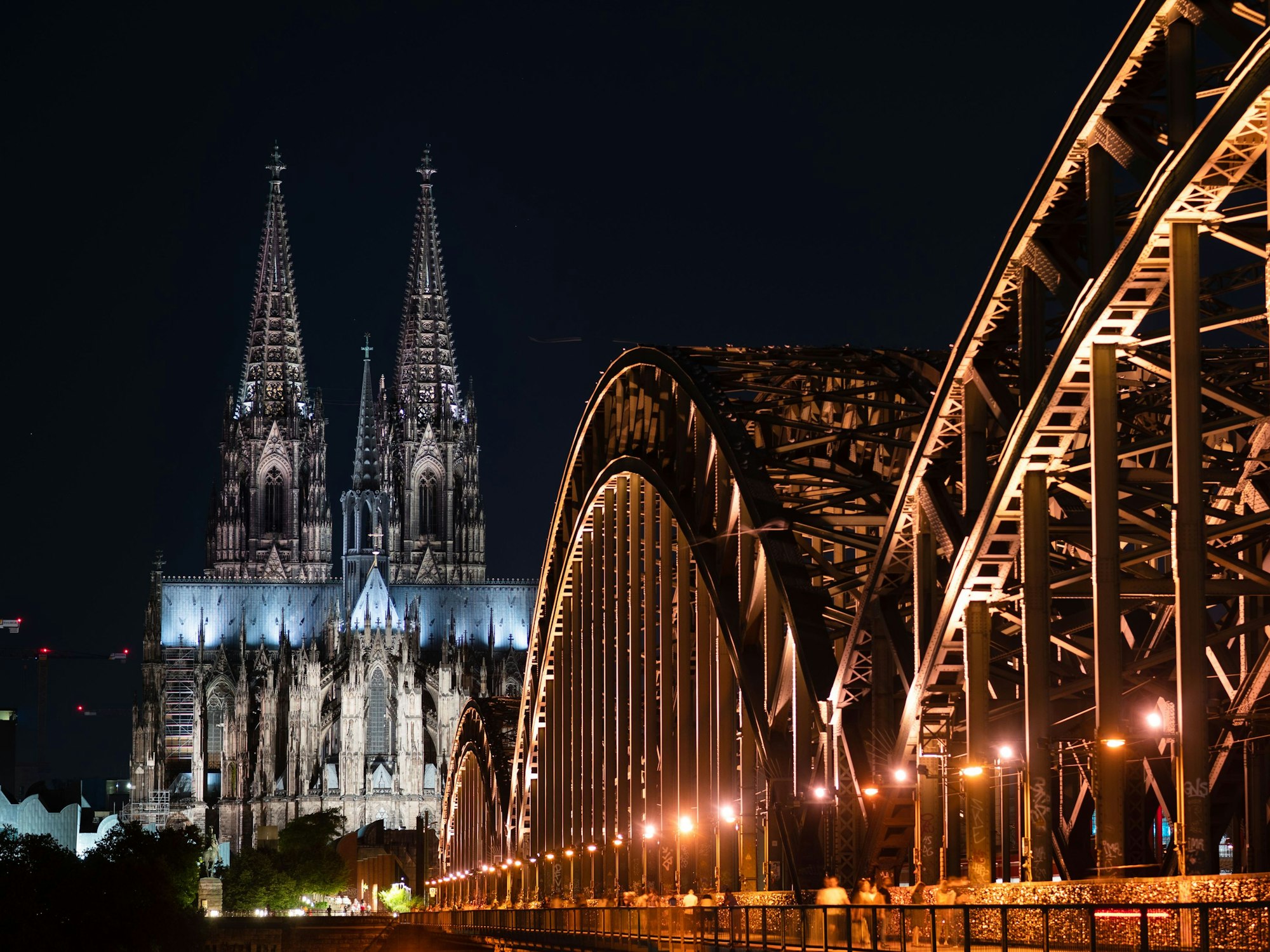 Das Foto zeigt den beleuchteten Dom und die Hohenzollern Brücke.