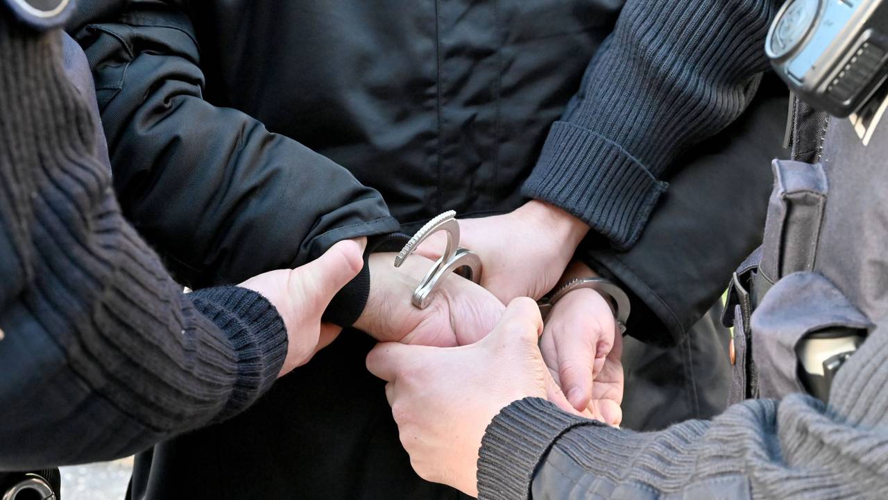 Gestellte Szene einer Festnahme durch Polizisten.