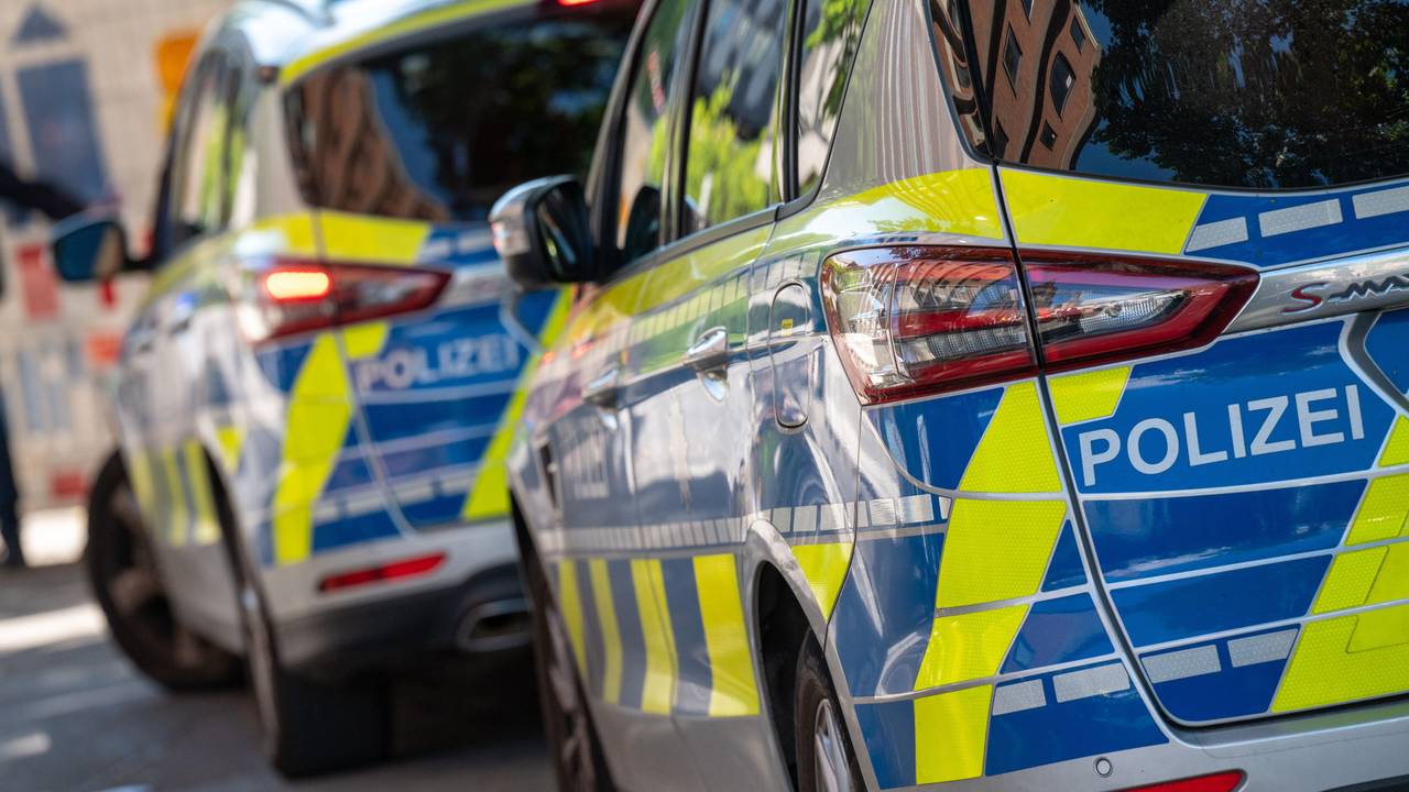 Zwei Polizeifahrzeuge stehen an der Straße