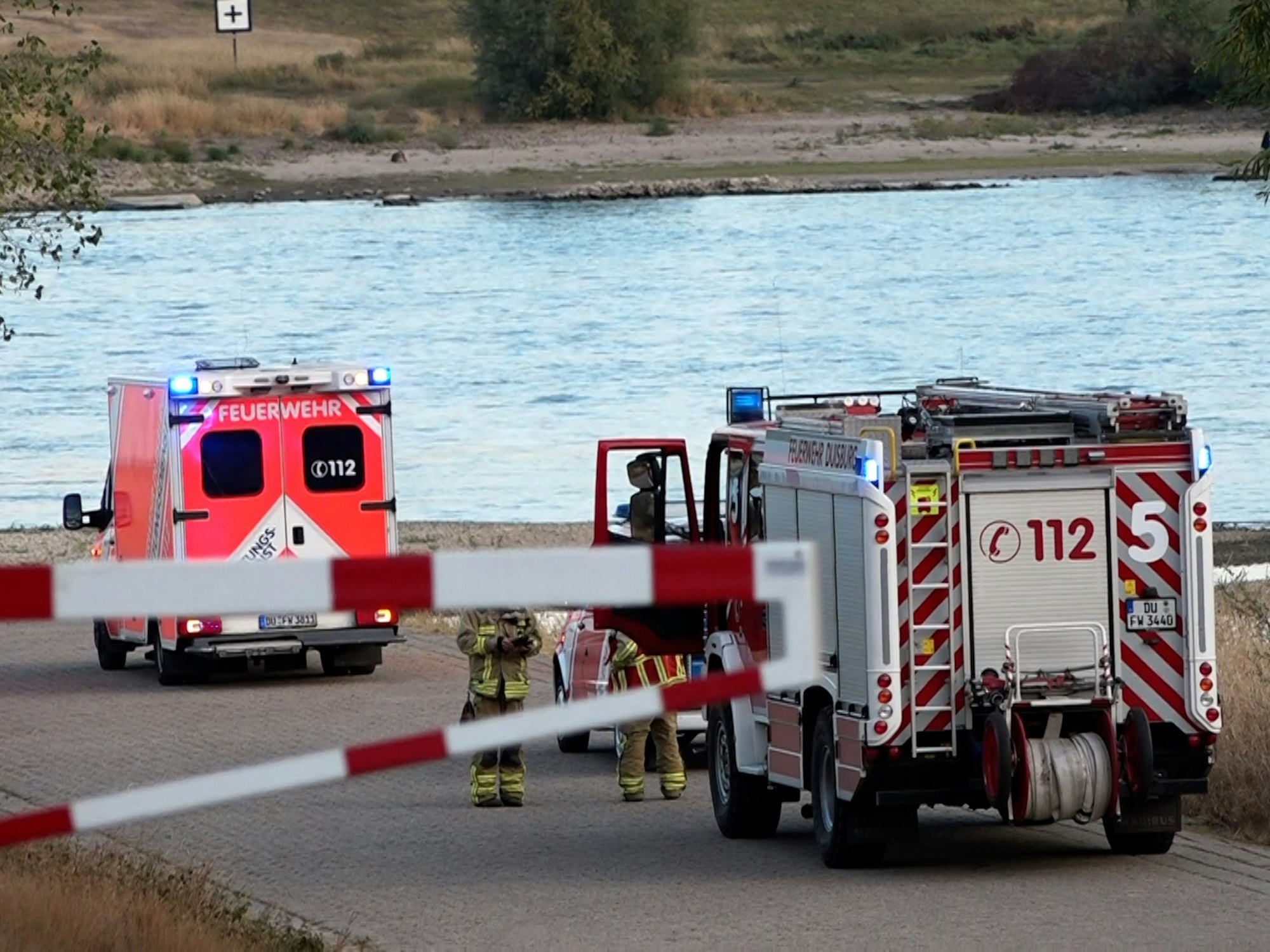 Fahrzeuge der Feuerwehr stehen am Rhein.