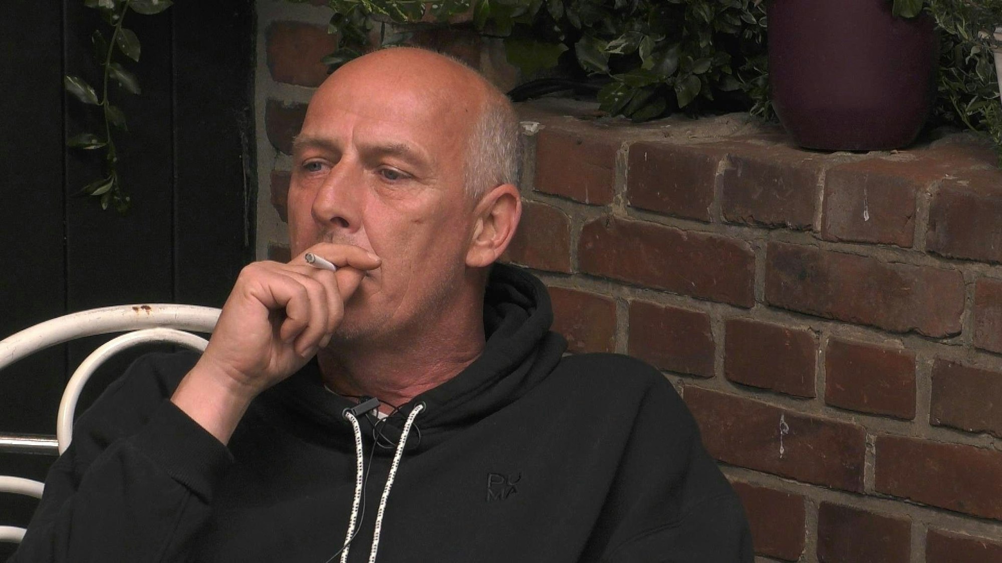 Mario Basler raucht eine Zigarette.