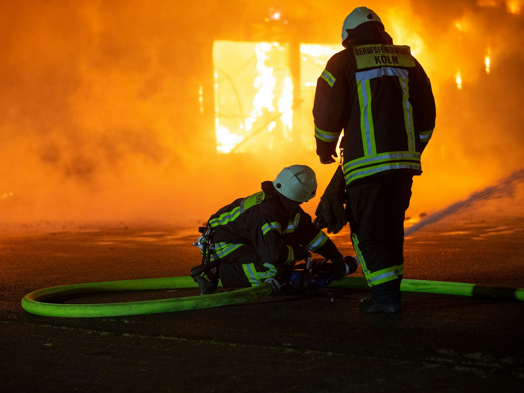 Feuerwehrleute löschen den Brand einer Lagerhalle.