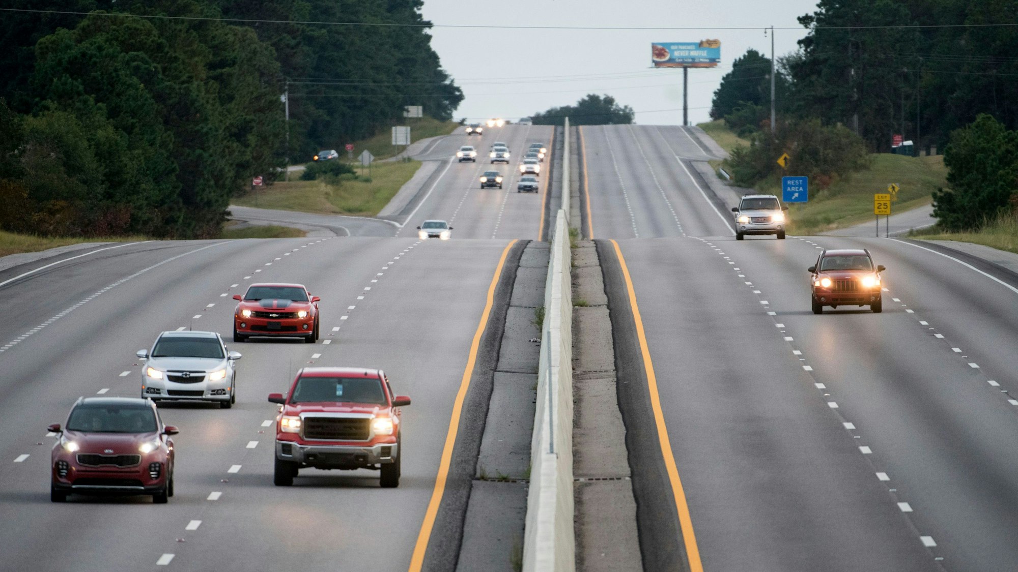 Das Symbolfoto von 2018 zeigt eine amerikanische Autobahn. Beide Richtungen sind dreispurig, links und rechts stehen Bäume.