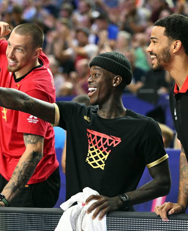 Deutschlands Daniel Theis (l.),Dennis Schröder und Nick Weiler-Babb verfolgen das Spiel auf der Bank.