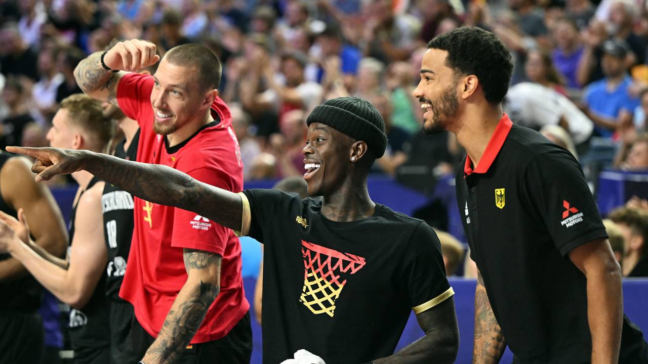 Deutschlands Daniel Theis (l.),Dennis Schröder und Nick Weiler-Babb verfolgen das Spiel auf der Bank.