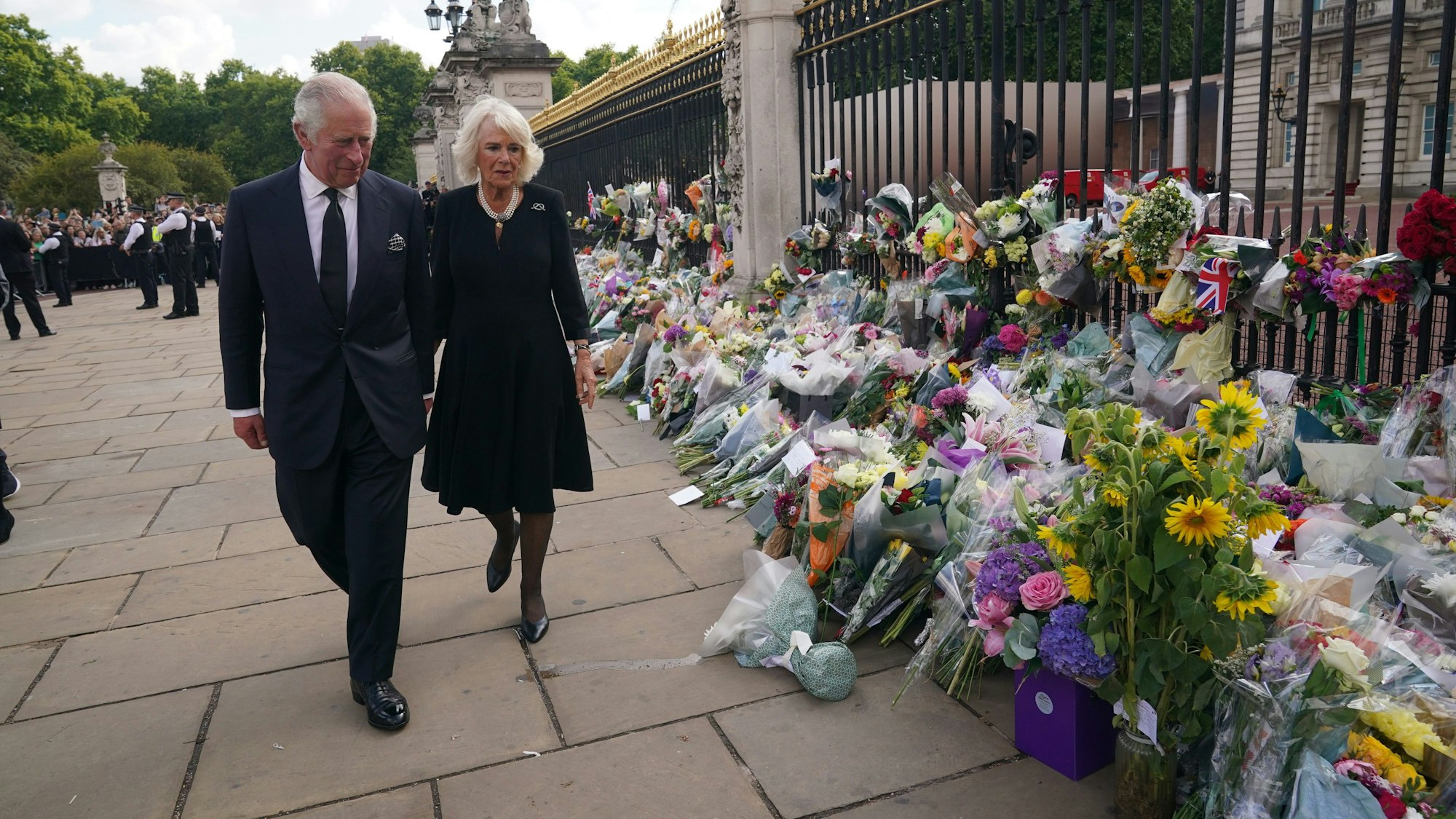 König Charles III. und seine Frau Camilla sehen sich die Blumengestecke und persönlichen Grußworte an, die nach dem Tod von Königin Elizabeth II. vor dem Buckingham-Palast abgelegt wurden.