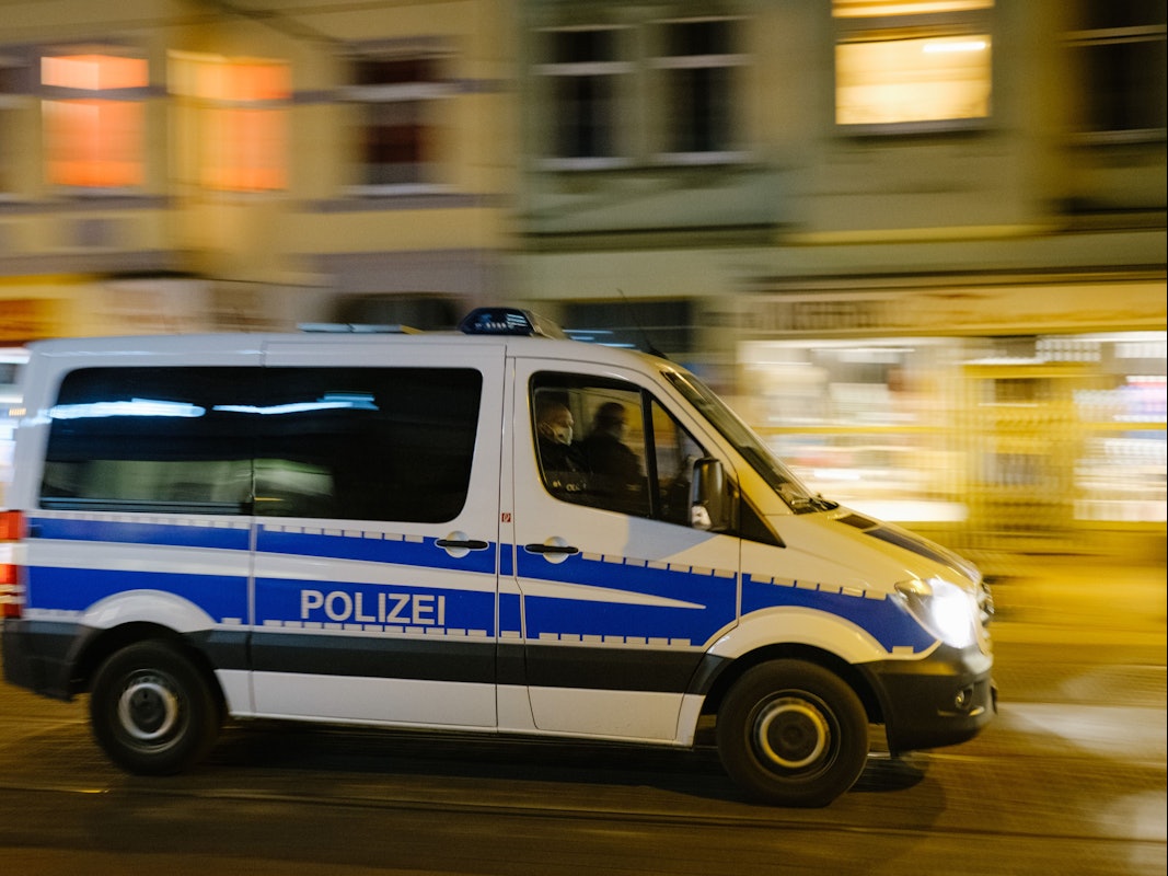Ein Polizeiwagen fährt über eine Straße.