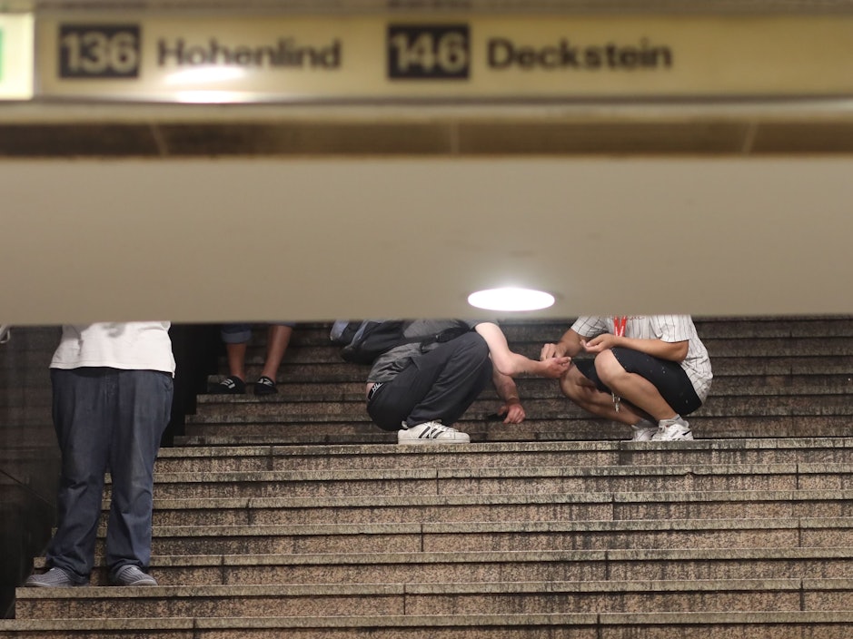 28.06.2022, Köln: An der HUGO Passage am Neumarkt, Dealer und Konsumenten treffen aufeinander. Zwei Passanten auf der Treppe zur U-Bahn hier findet gerade ein Geschäfte statt und wird sich direkt vor Ort ein Schuß gegeben. Foto: Arton Krasniqi