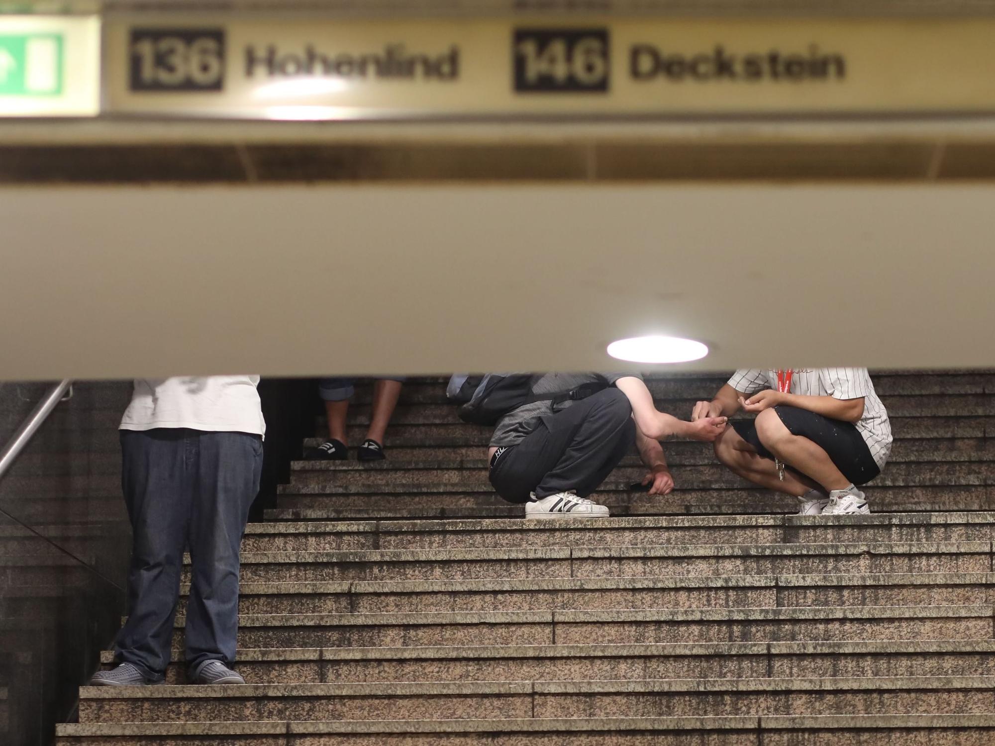 28.06.2022, Köln: An der HUGO Passage am Neumarkt, Dealer und Konsumenten treffen aufeinander. Zwei Passanten auf der Treppe zur U-Bahn hier findet gerade ein Geschäfte statt und wird sich direkt vor Ort ein Schuß gegeben. Foto: Arton Krasniqi