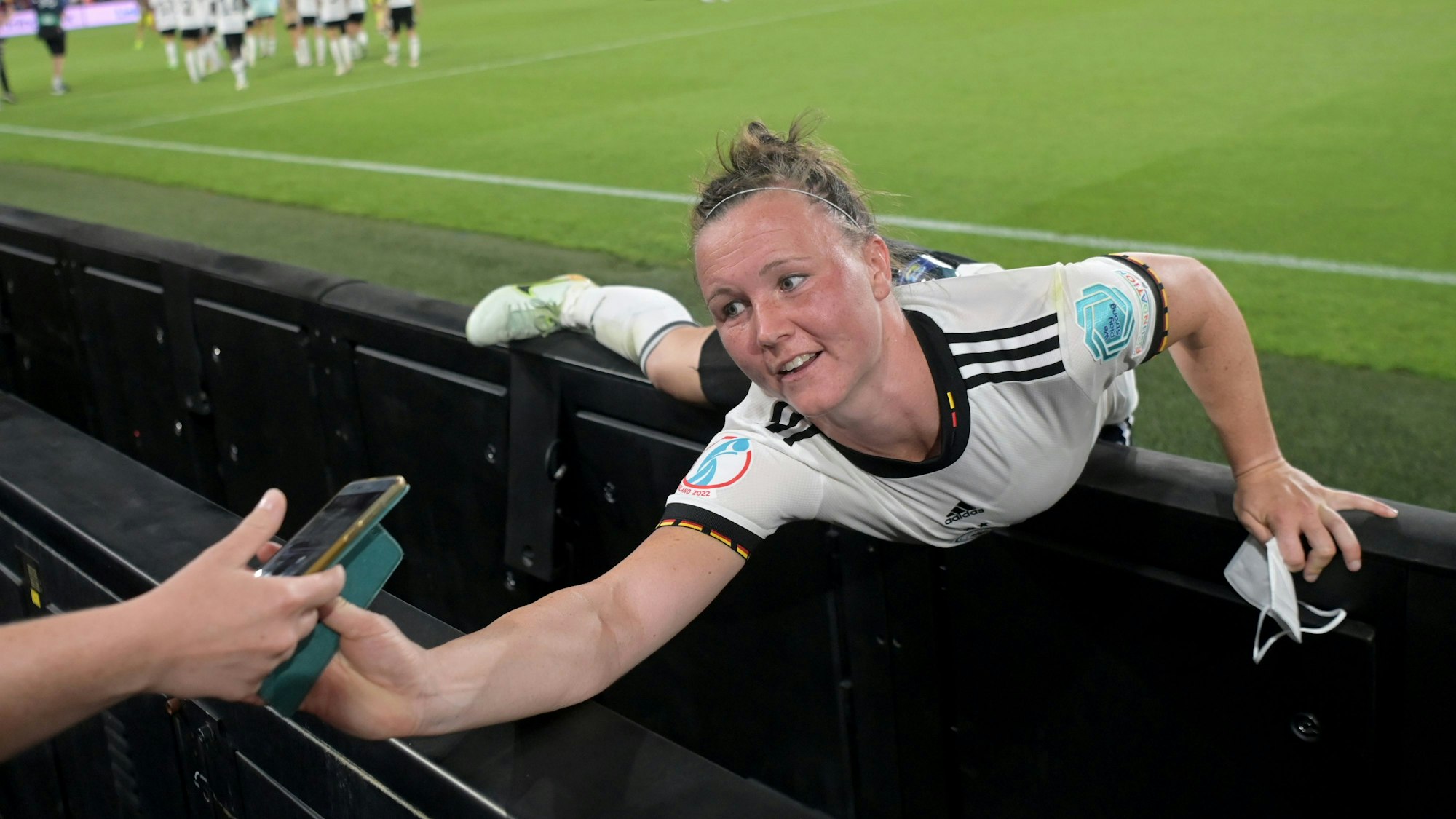 Deutschlands Marina Hegering streckt sich nach dem Spiel nach einem Smartphone.