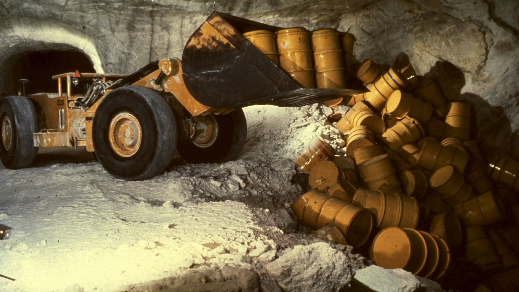 Das undatierte Symbolbild zeigt einen Radlader, der in der Schachtanlage Asse (Niedersachsen) Fässer mit radioaktivem Müll in eine Kammer kippt.