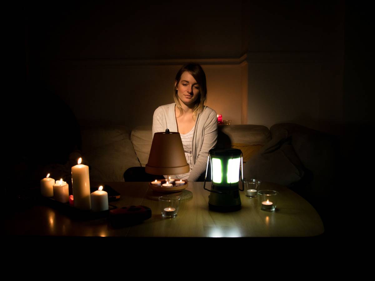 Der Deutsche Städte- und Gemeindebund fürchtet eine Überlastung des Stromnetzes. Auf einen Blackout sei Deutschland jedoch zu wenig vorbereitet. Unser Symbolbild zeigt eine Frau vor Kerzen und Teelichtern.