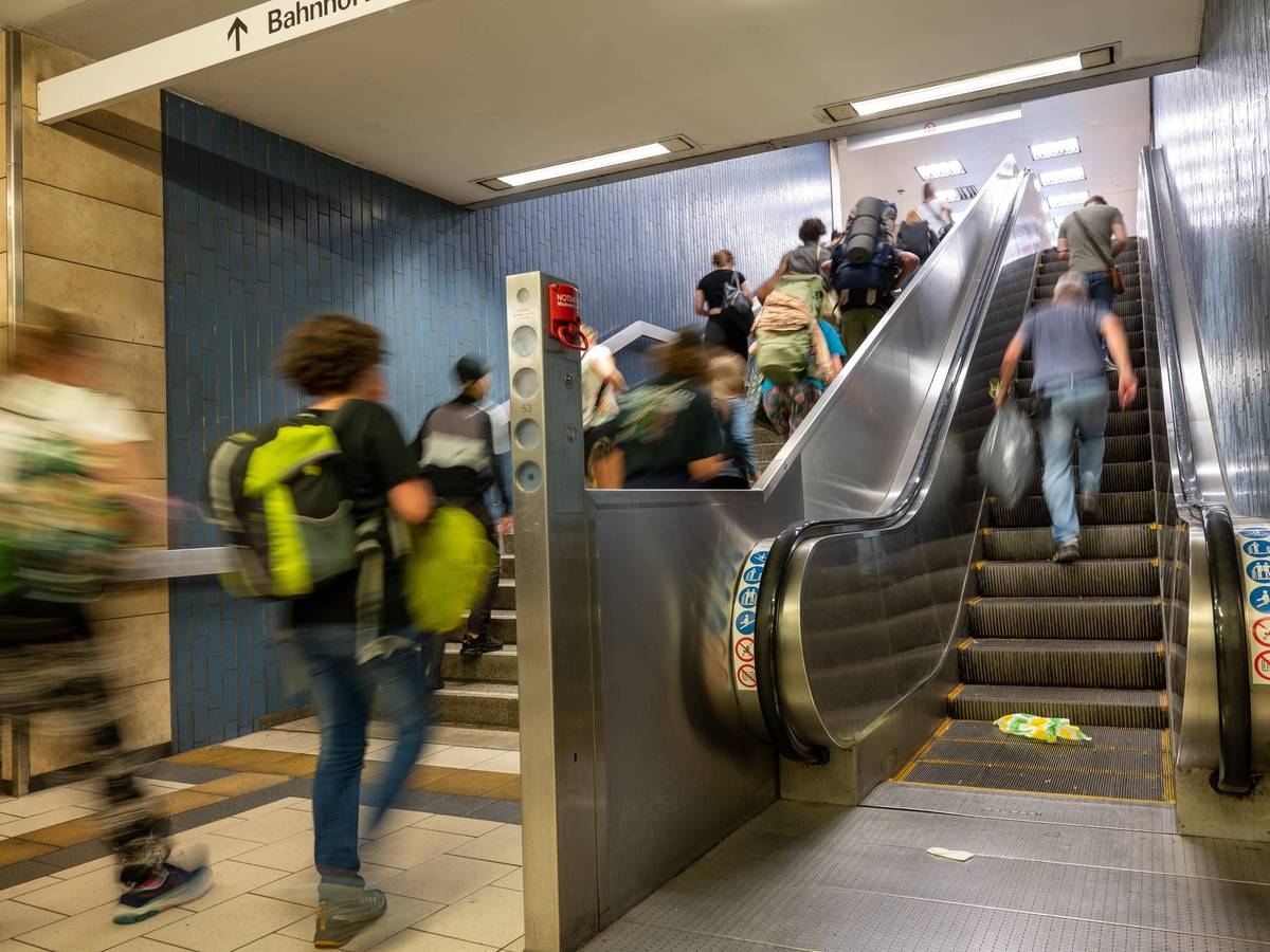 Menschen gehen am Kölner Hauptbahnhof eine Treppe hoch.