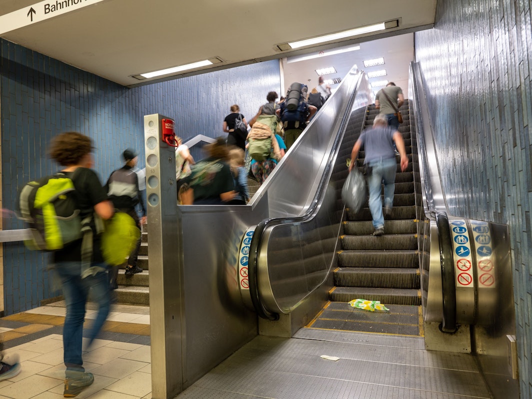 Menschen gehen am Kölner Hauptbahnhof eine Treppe hoch.