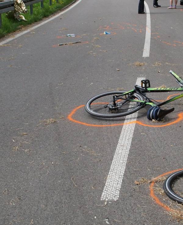 Der Vorderreifen eines Fahrrads liegt neben dem Fahrrad an einer Unfallstelle. Beides ist mit Markierungen der Polizei gekennzeichnet.