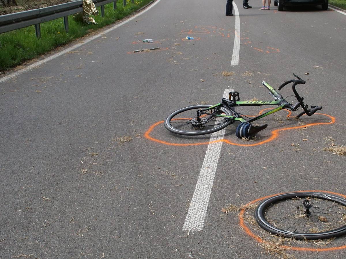 Der Vorderreifen eines Fahrrads liegt neben dem Fahrrad an einer Unfallstelle. Beides ist mit Markierungen der Polizei gekennzeichnet.