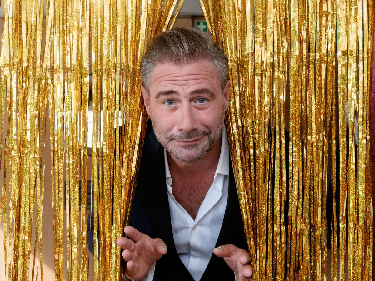 Der Sänger und Entertainer Sasha sieht auf einem Pressetermin zur Vorstellung seiner Show "This Is My Time - Die Show" durch einen goldenen Lametta-Vorhang.
