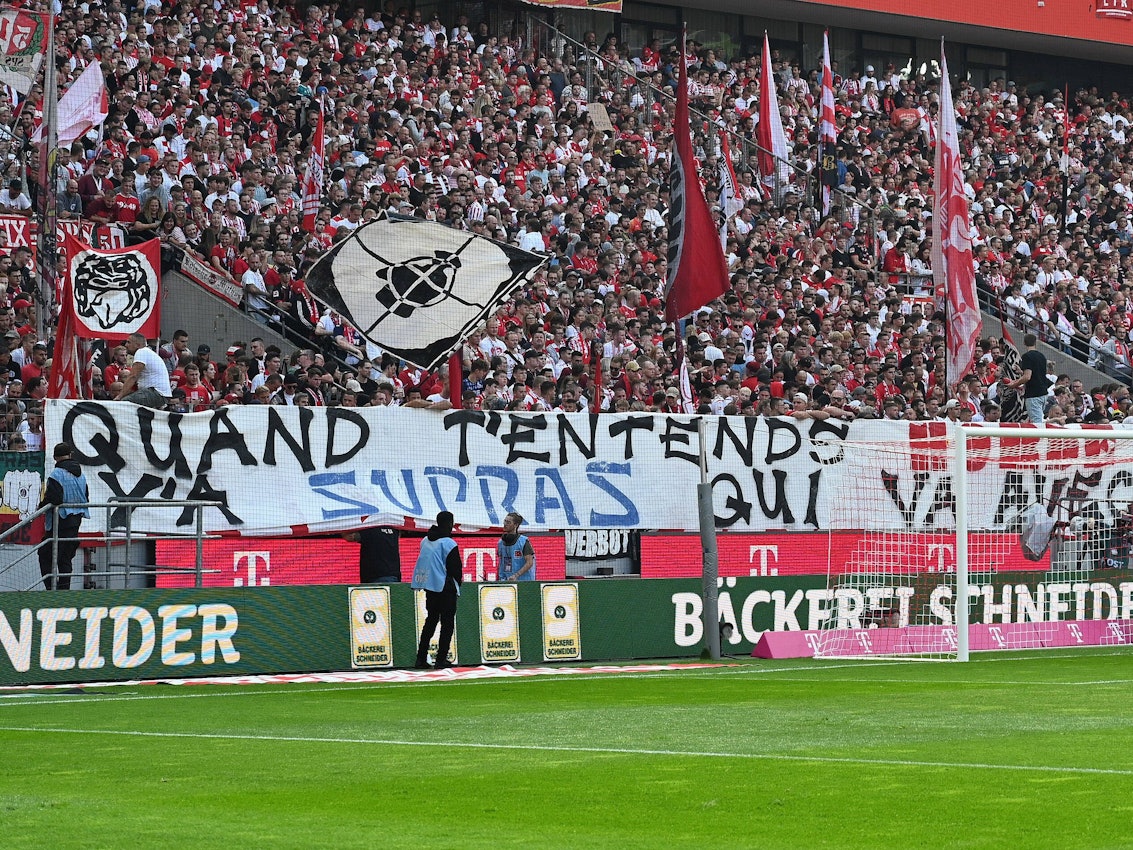 Fans des 1. FC Köln präsentieren beim Bundesliga-Spiel gegen Union Berlin ein Banner auf Französisch