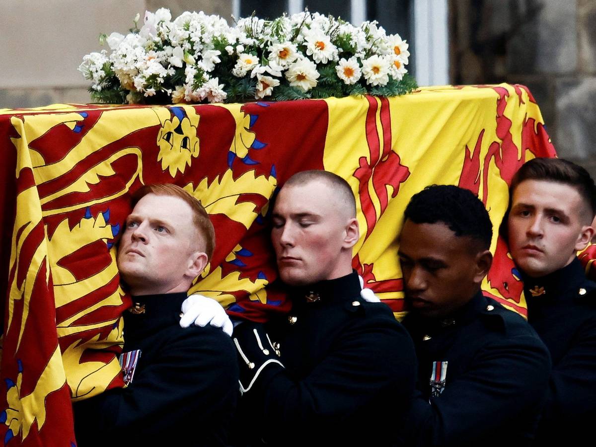 Sargträger tragen den mit der königlichen Standarte von Schottland drapierten Sarg von Königin Elizabeth II. bei seiner Ankunft am 11. September 2022 in Holyroodhouse, wo er einen Tag lang ruhen wird.