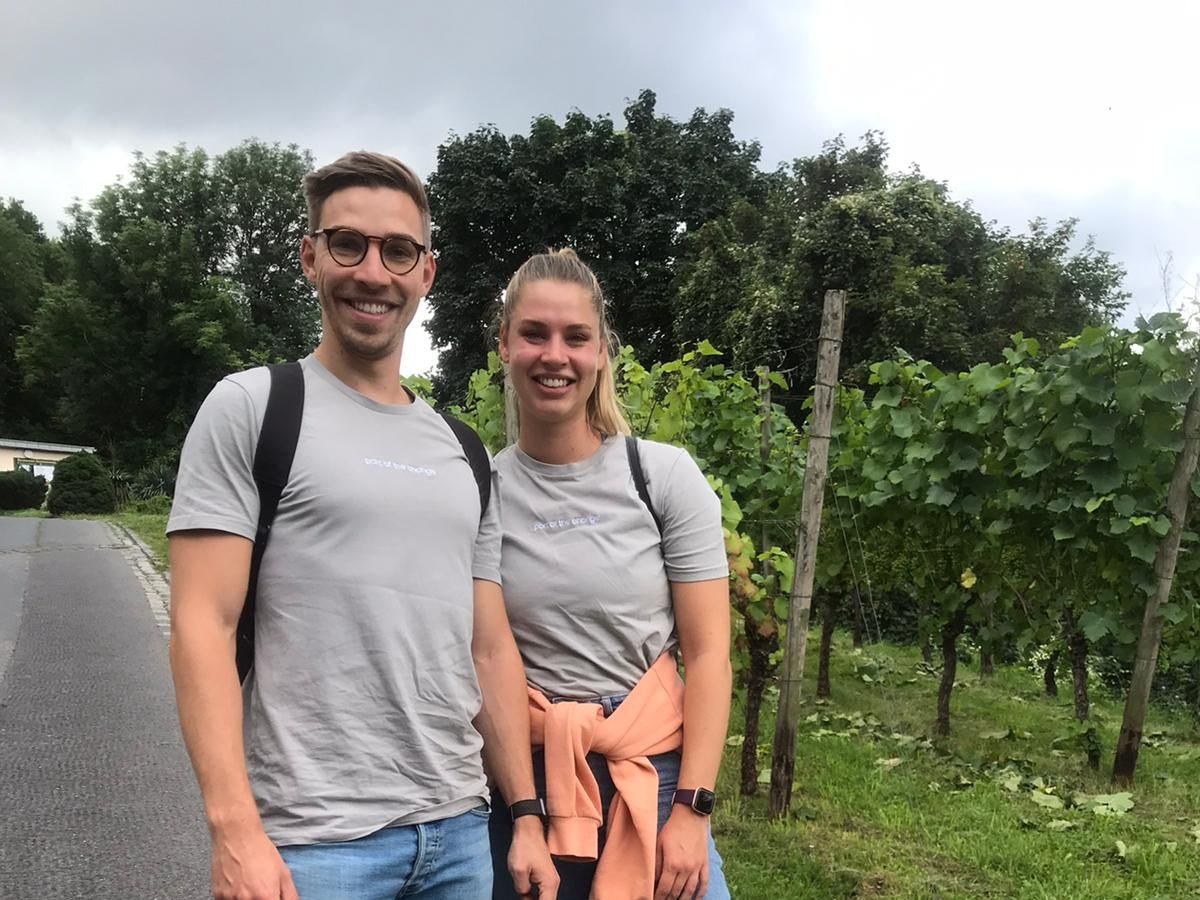 Die Geschwister Max und Luisa aus Köln posieren vor einem Weinberg.