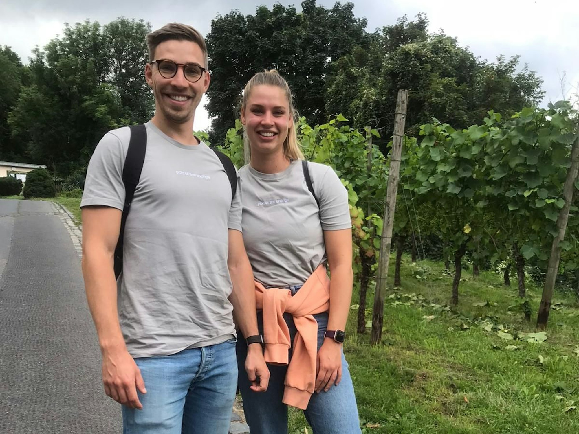Die Geschwister Max und Luisa aus Köln posieren vor einem Weinberg.