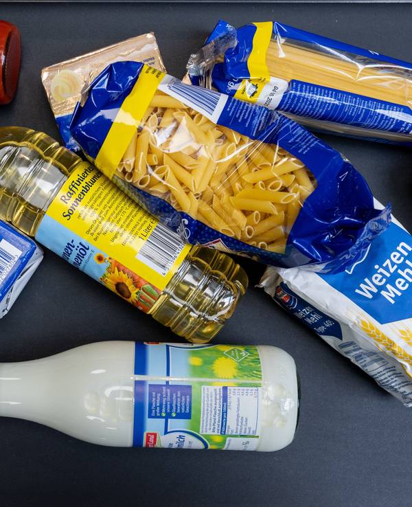 Lebensmittel, darunter Sonnenblumenöl und Getreideprodukte, liegen in einem Supermarkt in Leipzig an der Kasse auf dem Band.