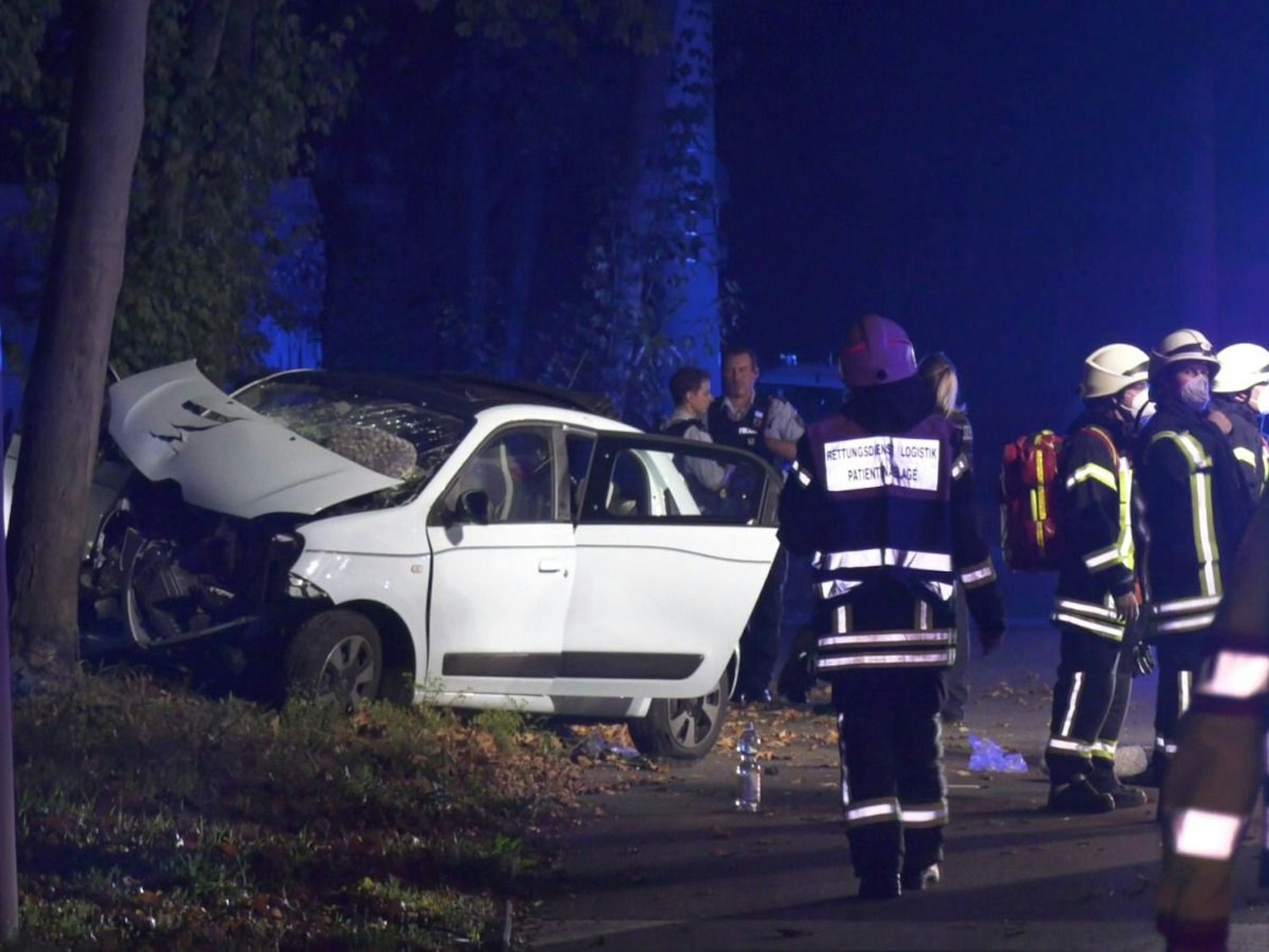 Feuerwehrleute befinden sich an der Unfallstelle am Pfälzischen Ring, wo ein Renault Twingo gegen einen Baum gekracht war.