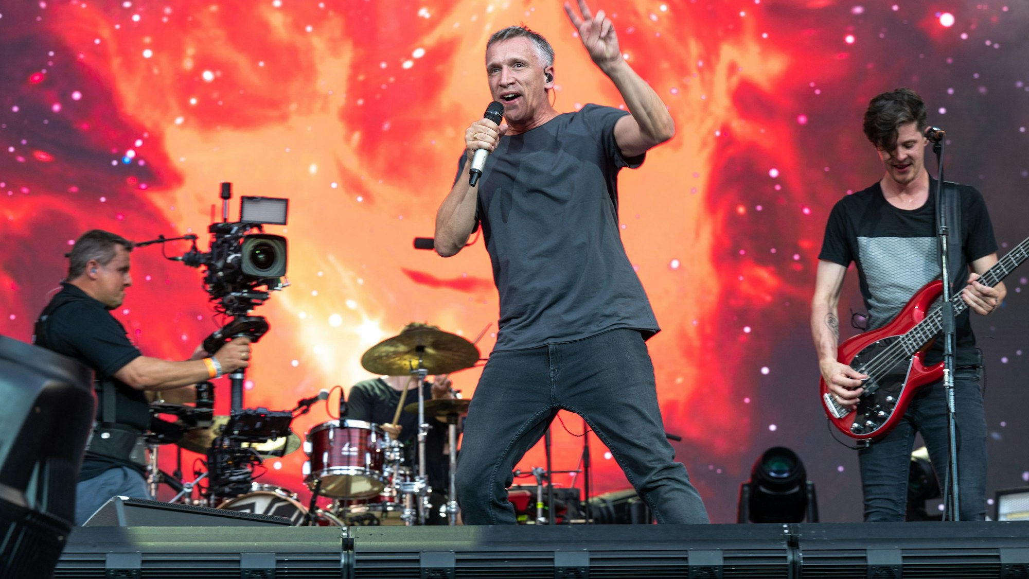 Eine Band steht auf der Bühne, vor der Sänger.