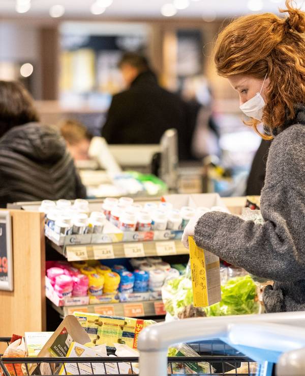 Eine Kundin steht bei Edeka an der Kasse.