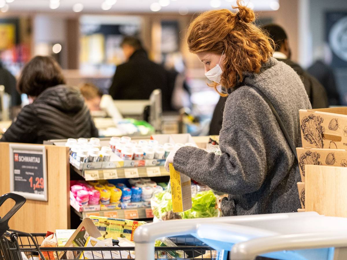 Eine Kundin steht bei Edeka an der Kasse.