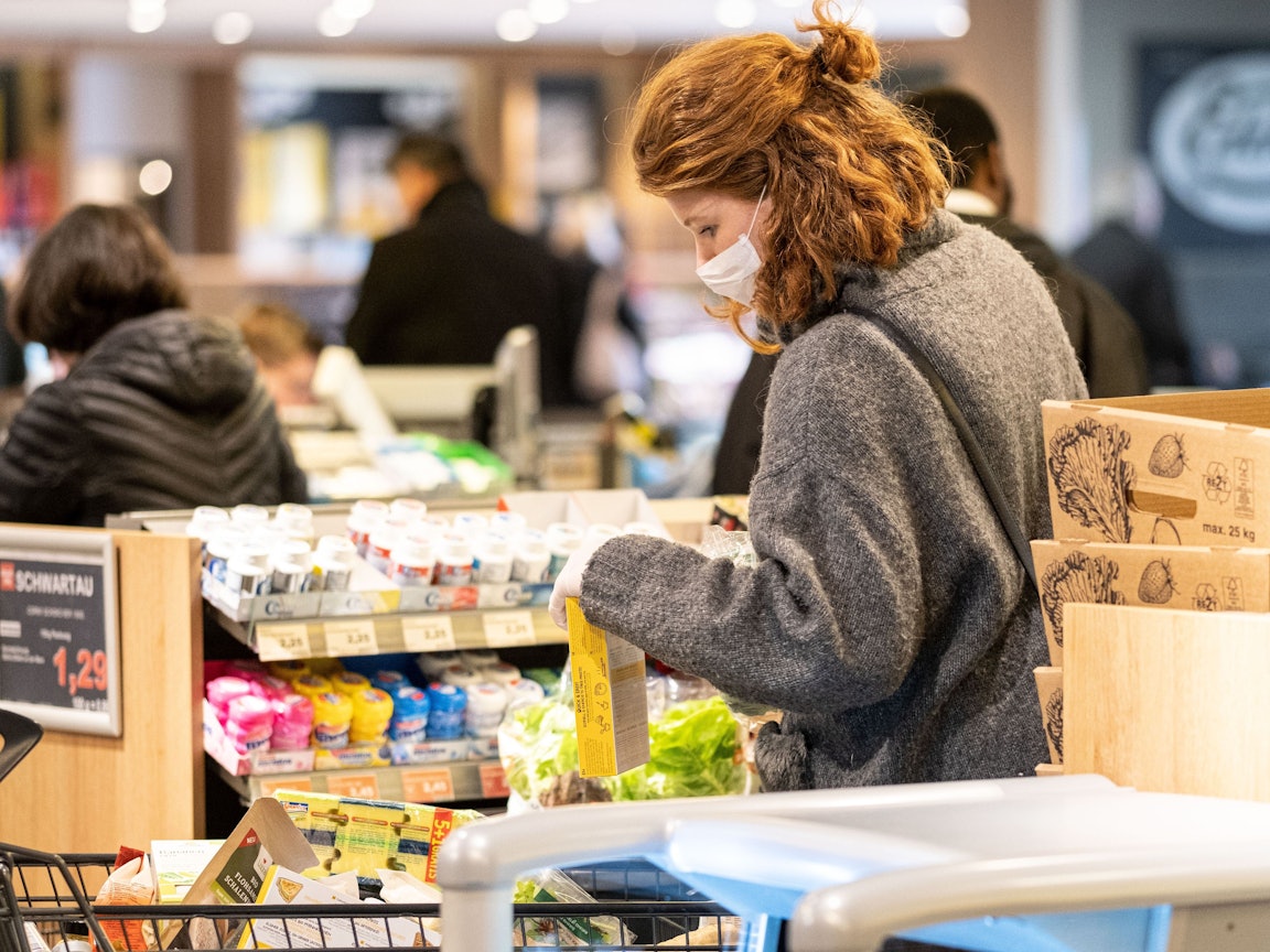 Eine Kundin steht bei Edeka an der Kasse.