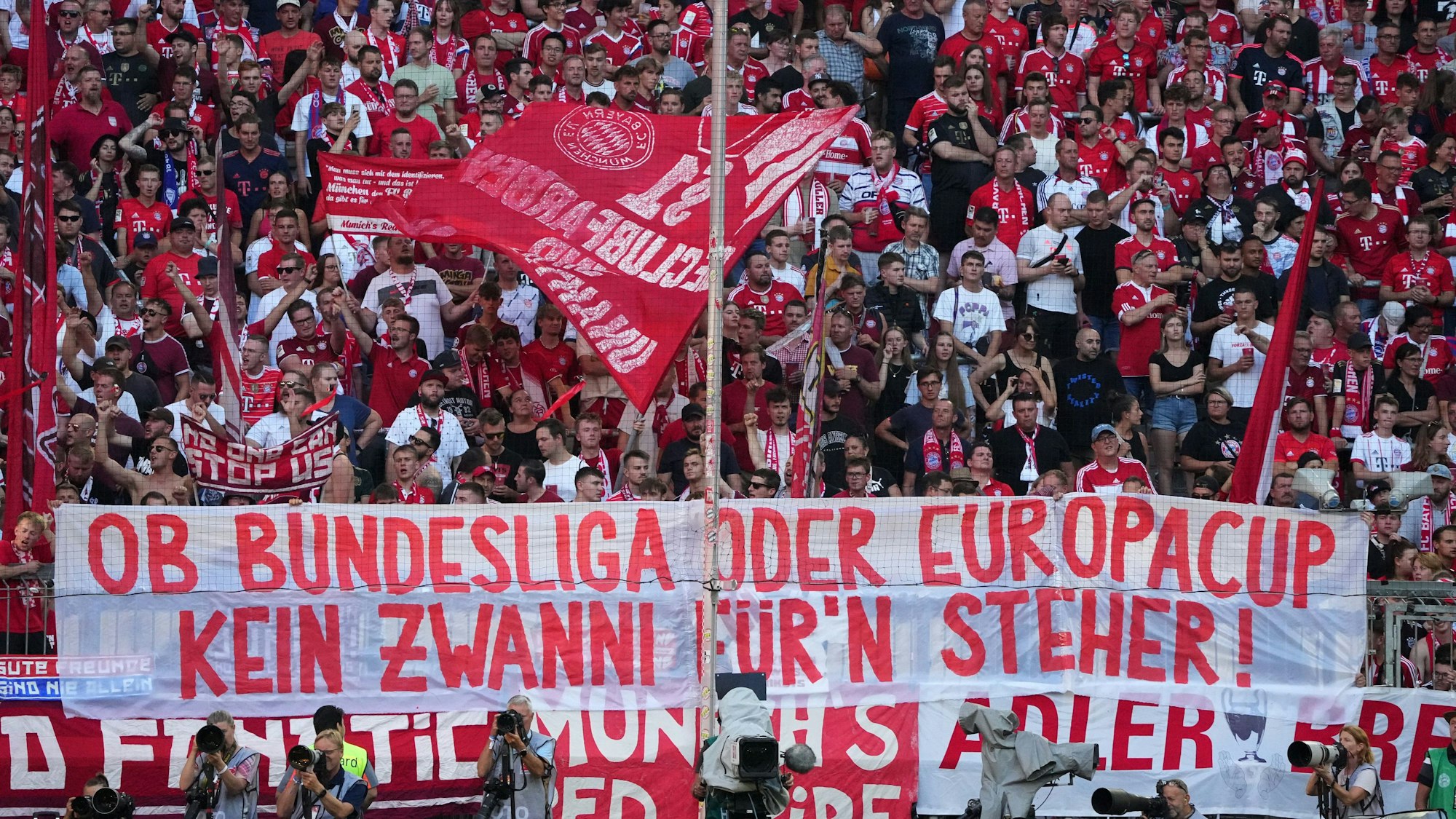 Fans des FC Bayern haben ein Transparent mit der Aufschrift "Ob Bundesliga oder Europacup, kein Zwanni für'n Steher!" am Zaun aufgehängt.