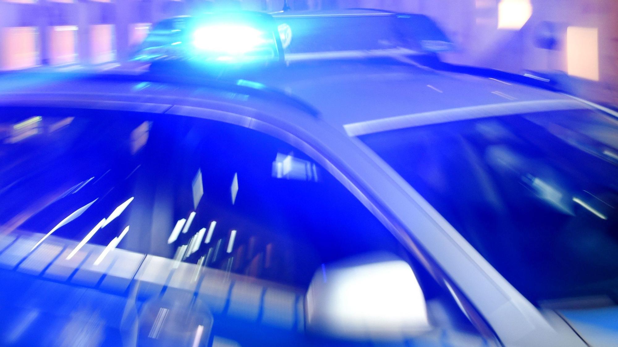 Ein Streifenwagen der Polizei steht mit eingeschaltetem Blaulicht auf der Strasse.